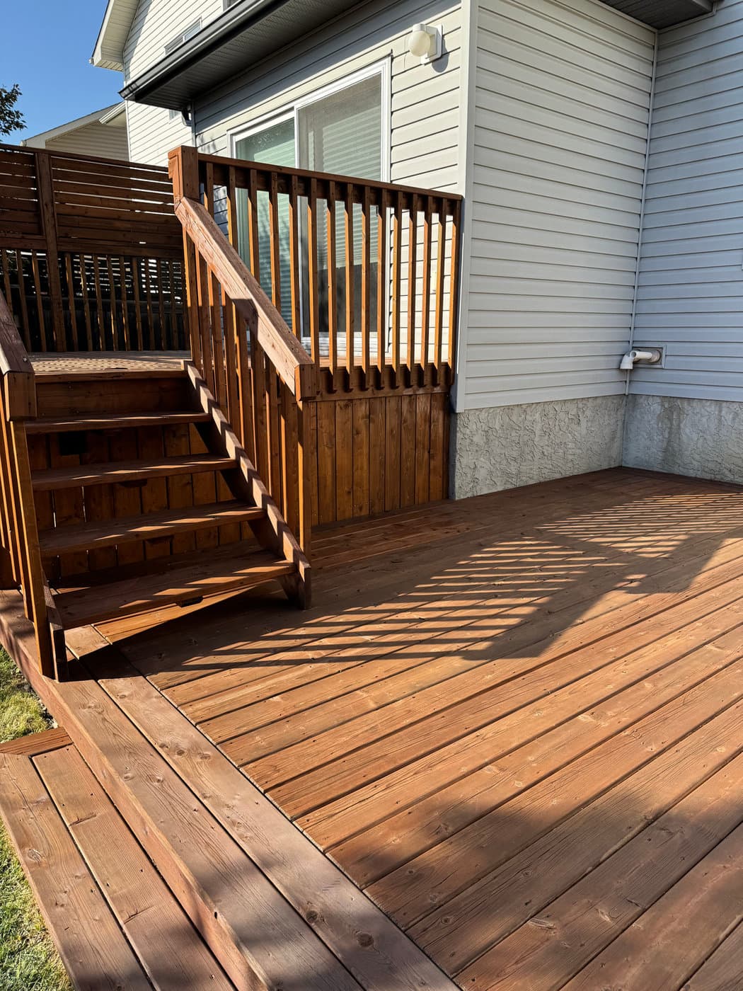 Coordinated deck and exterior siding refresh. Both surfaces specced against substrate, prepped, and finished together.