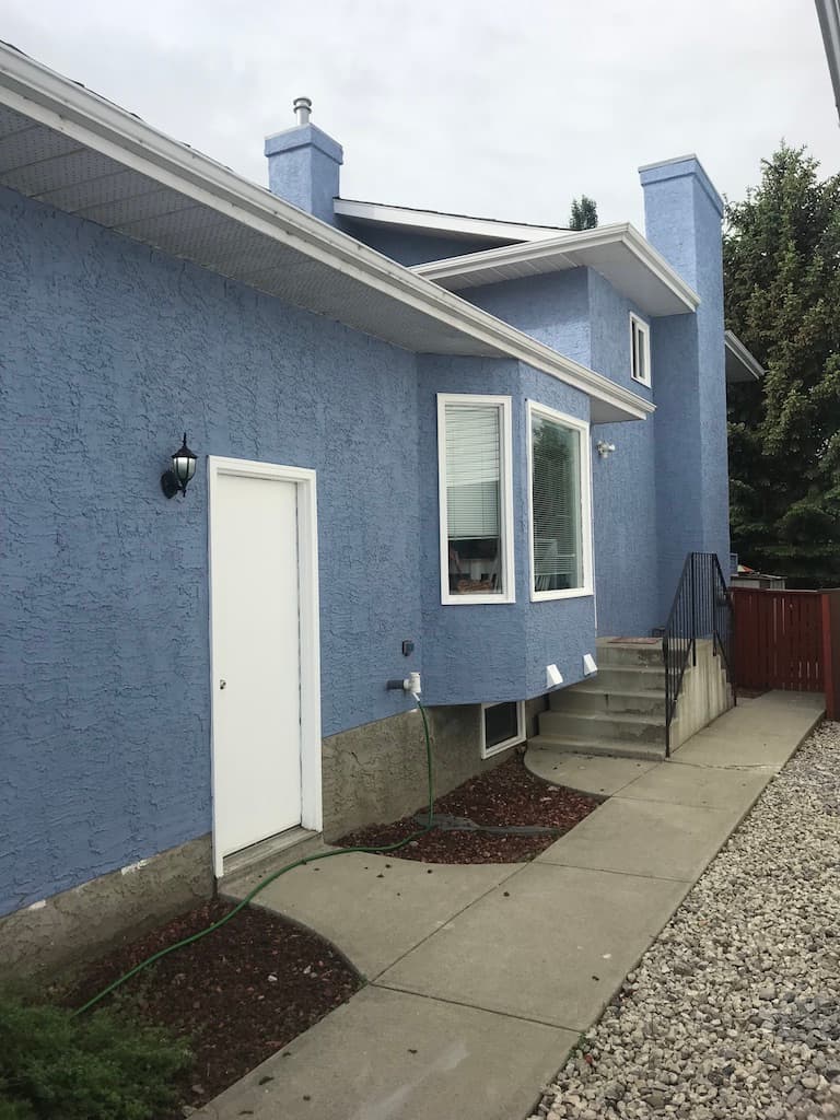 Exterior stucco refresh. Patched, primed, and sprayed in a custom-matched colour. Substrate tested before the first coat.