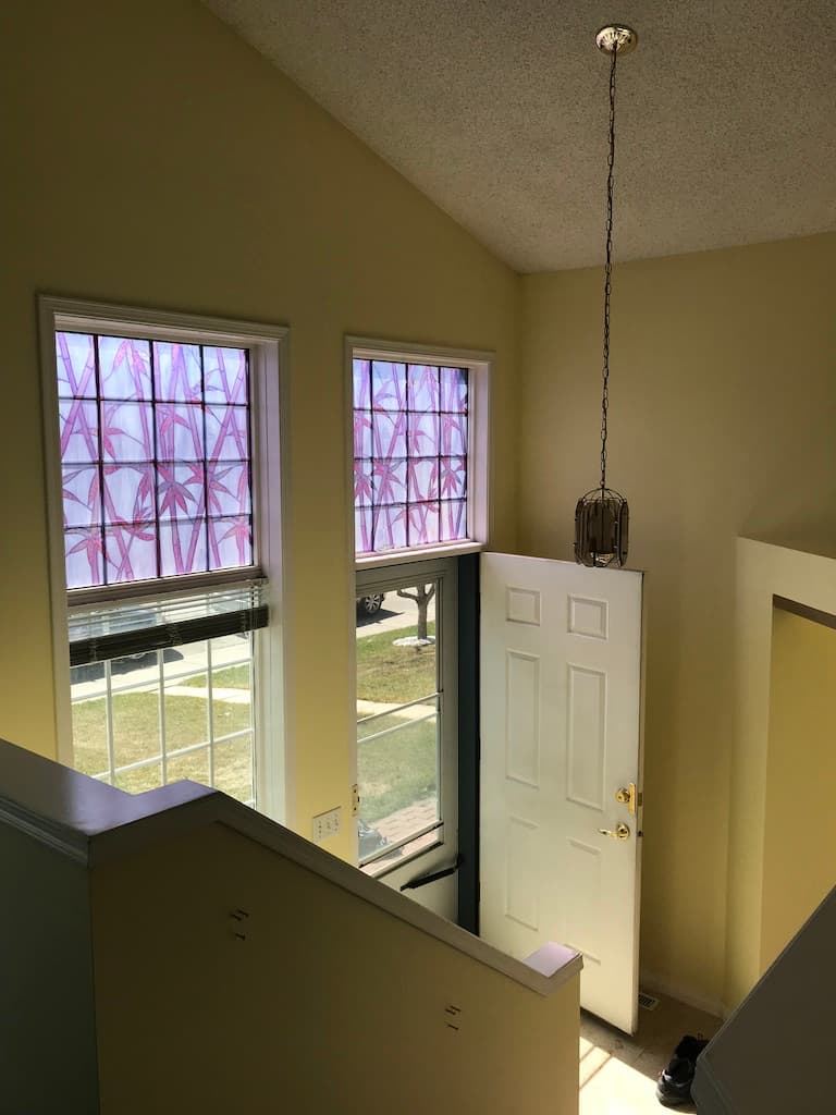 Vaulted ceiling and staircase railing. Two-tone finish keeps the architectural detail readable from across the room. Sanded between coats, dust-controlled workflow.